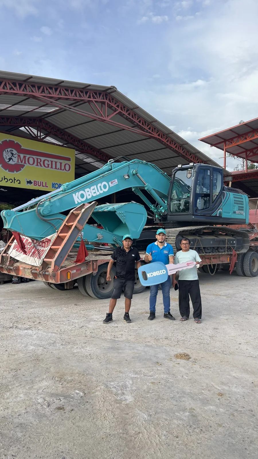 Clientes y personal junto a una excavadora Kobelco en las instalaciones de Morgillo