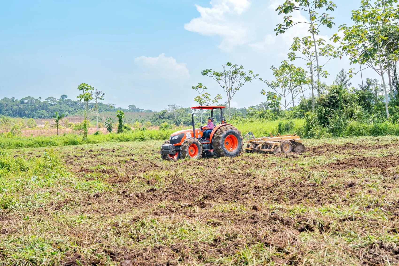 Tractor Kubota trabajando la tierra en un campo agrícola